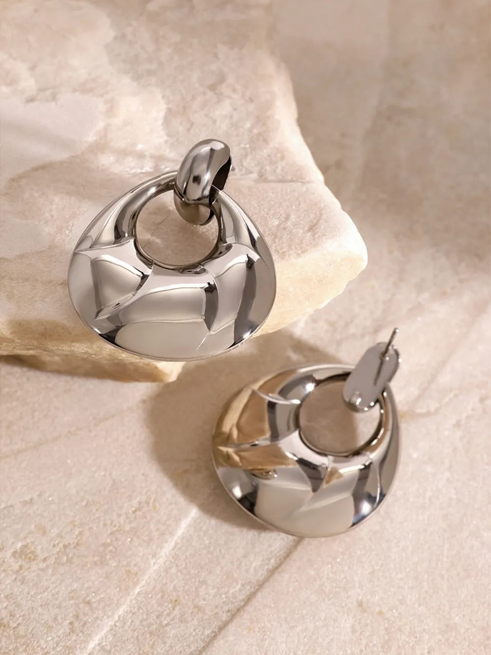 Two silver door handles on a stone surface