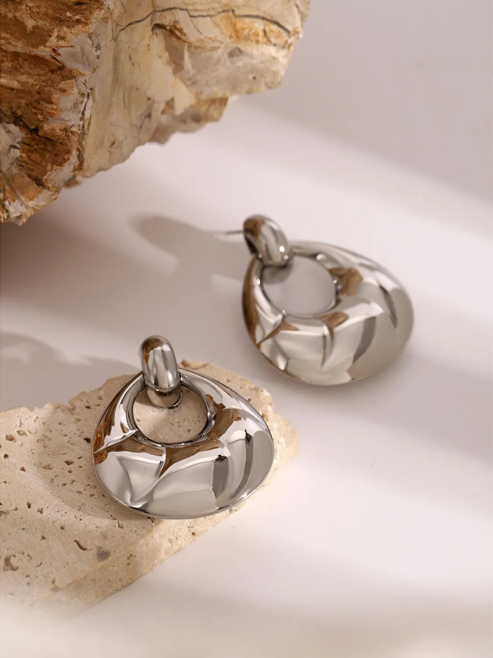 Pair of silver earrings on a textured surface