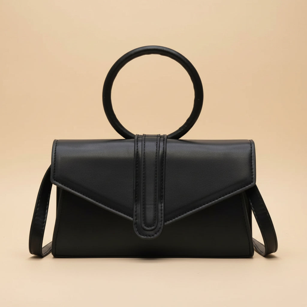 Black handbag with circular handle on a white background