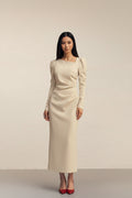 Beige dress with long sleeves and a subtle bow detail on a plain background
