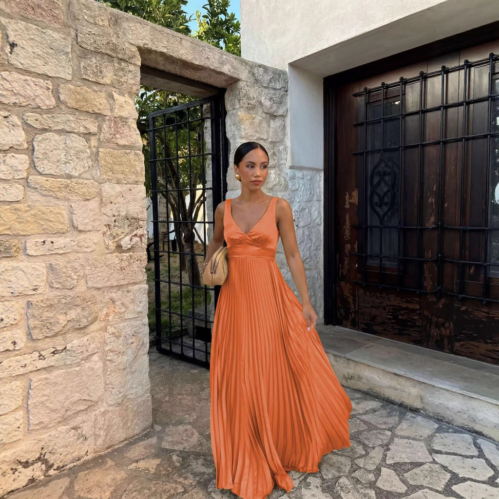 Woman in an orange dress standing in front of a stone building.
