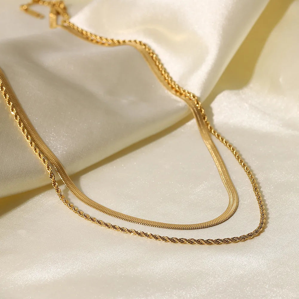 Gold chain necklace on a white fabric background