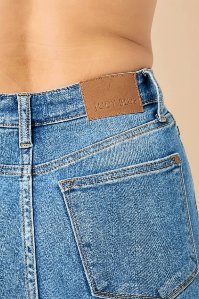 Close-up of blue jeans with a brand label on a white background