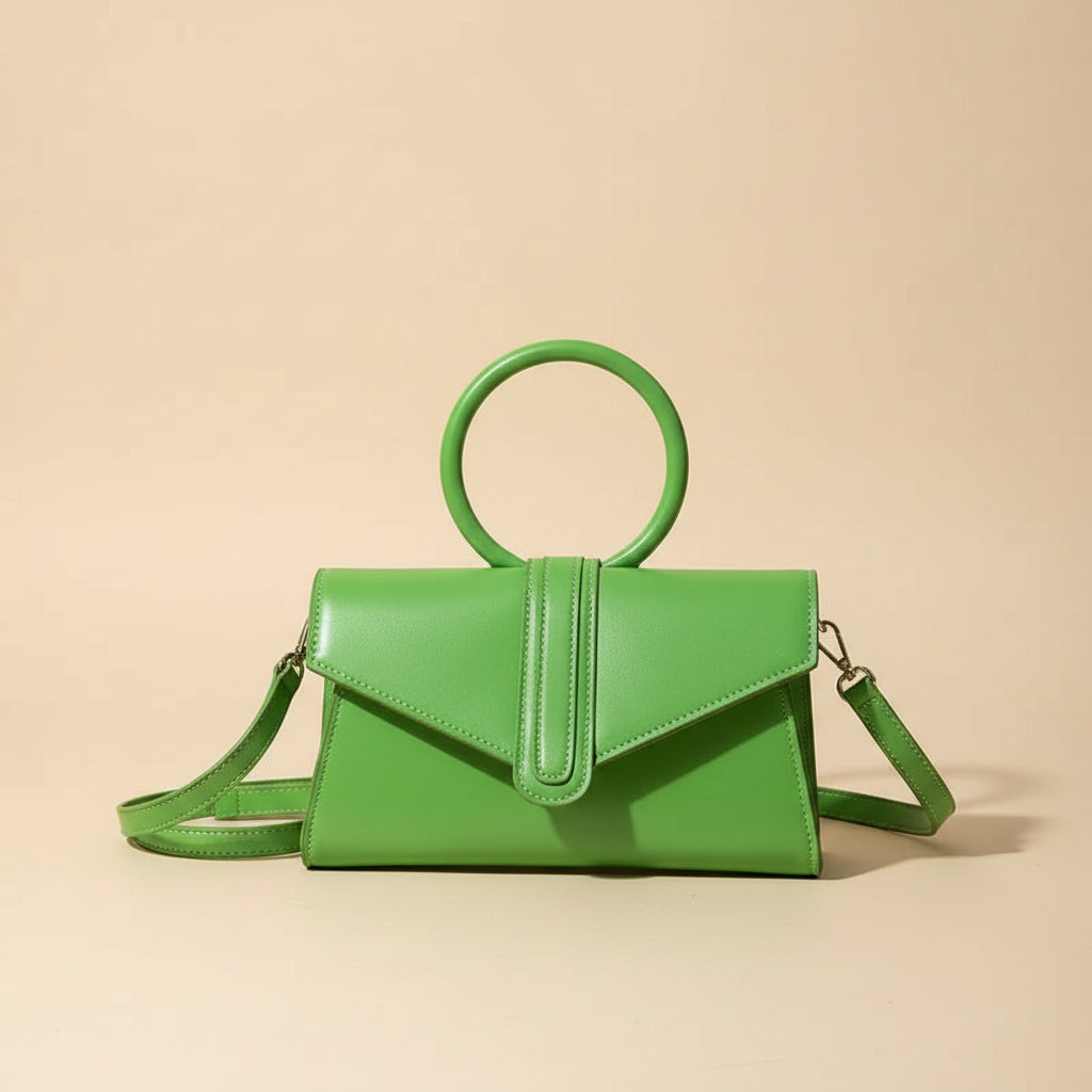 Green handbag on a table with a coffee cup in the background